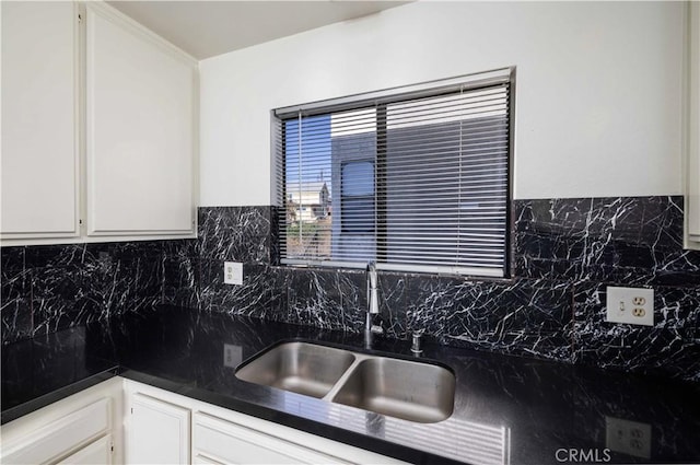 kitchen featuring tasteful backsplash, sink, and white cabinets