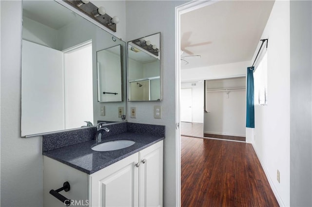 bathroom featuring hardwood / wood-style flooring, ceiling fan, and vanity