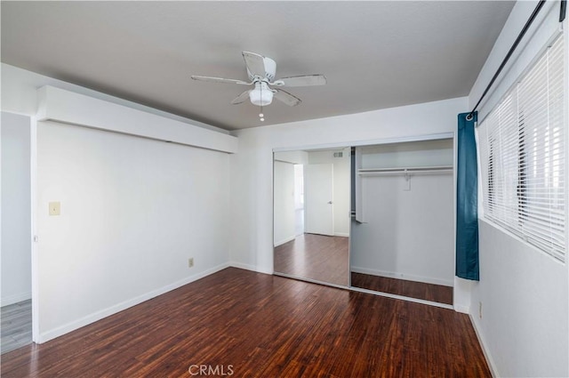 unfurnished bedroom with dark wood-type flooring, a closet, and ceiling fan