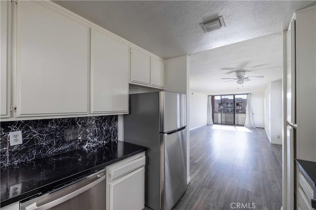 kitchen with hardwood / wood-style flooring, ceiling fan, white cabinetry, backsplash, and stainless steel appliances