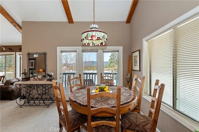 dining room featuring french doors, carpet flooring, and vaulted ceiling with beams