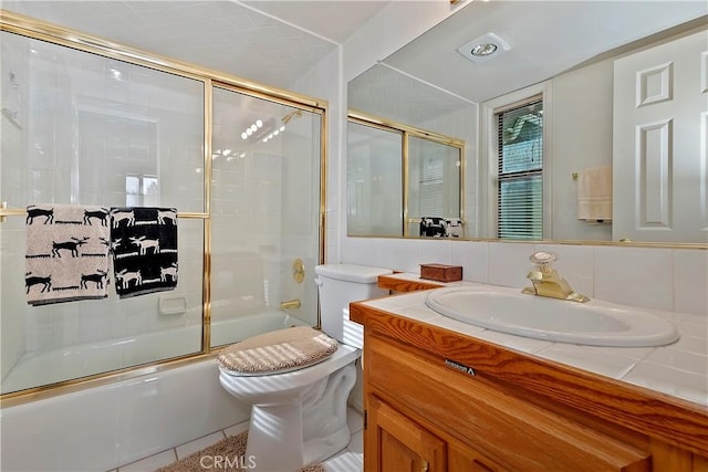 full bathroom with bath / shower combo with glass door, vanity, toilet, and decorative backsplash