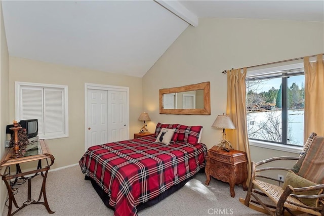 carpeted bedroom featuring lofted ceiling with beams and a closet