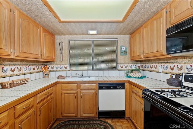 kitchen featuring tile countertops, range with gas cooktop, dishwasher, light parquet flooring, and a textured ceiling