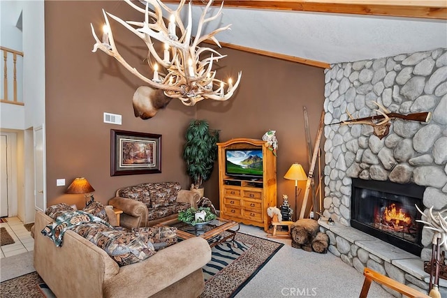 living room with a stone fireplace, beam ceiling, and a notable chandelier