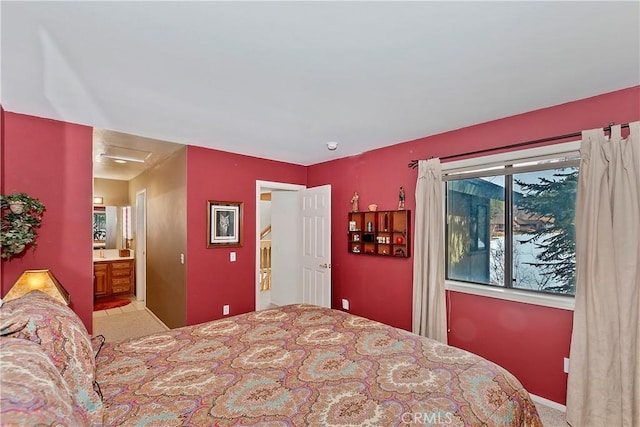 bedroom with ensuite bath and light colored carpet