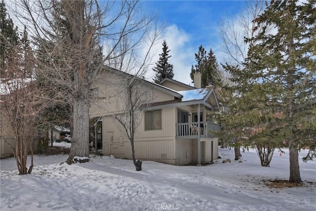 snow covered property featuring a balcony