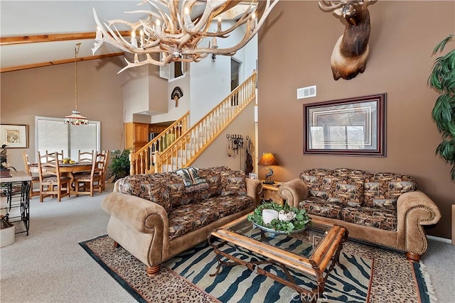 carpeted living room featuring a towering ceiling and a chandelier