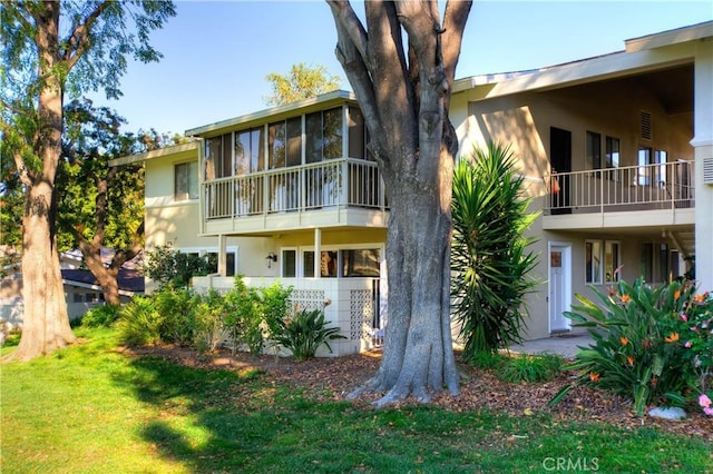 rear view of property featuring a lawn