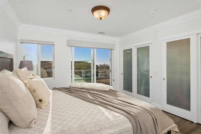 bedroom with access to exterior, visible vents, crown molding, and wood finished floors