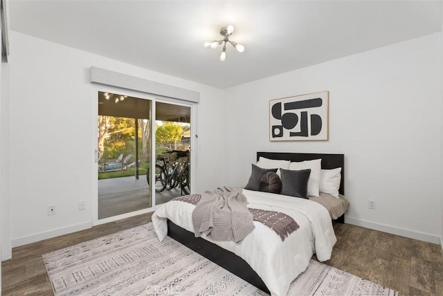 bedroom featuring baseboards, wood finished floors, and access to exterior