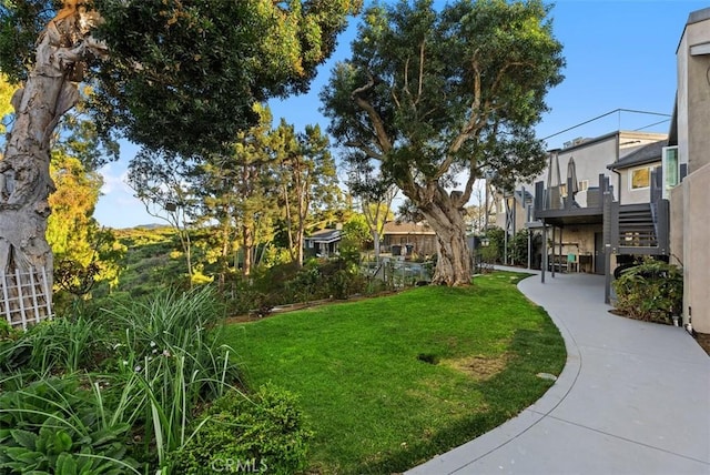 view of property's community with a patio area, stairway, and a yard