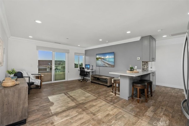 kitchen with crown molding, a breakfast bar area, and wood finished floors