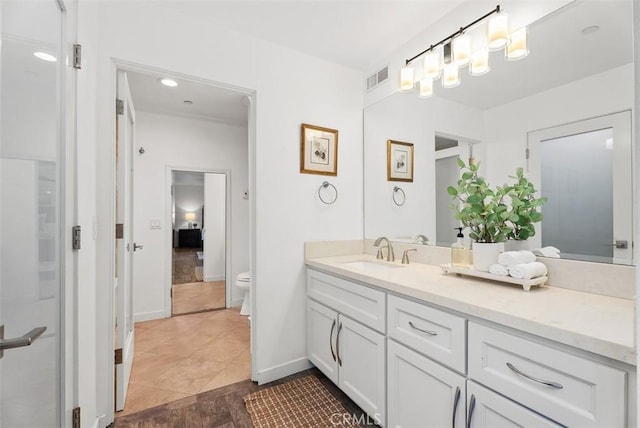 bathroom featuring baseboards, visible vents, vanity, and toilet