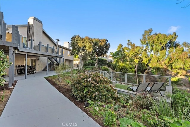 view of property's community with stairs, a patio area, and fence