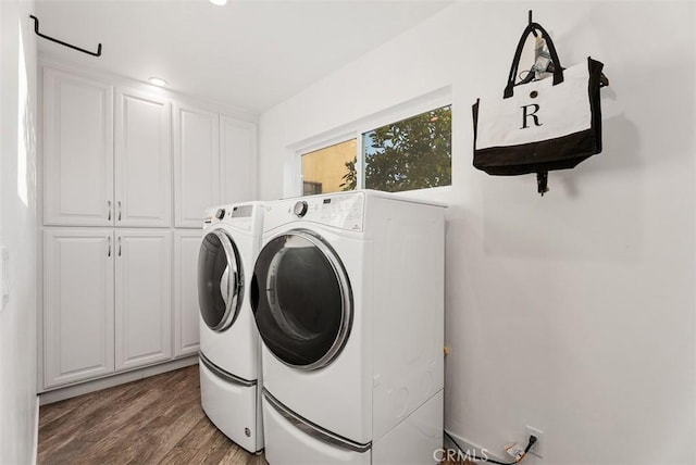 laundry room featuring cabinet space, separate washer and dryer, and wood finished floors