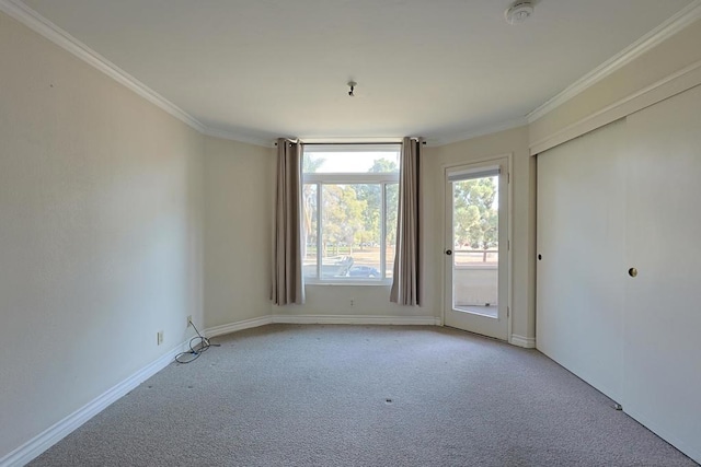 empty room featuring crown molding and light carpet