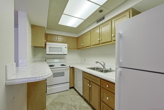 kitchen featuring white appliances, tile countertops, kitchen peninsula, and sink