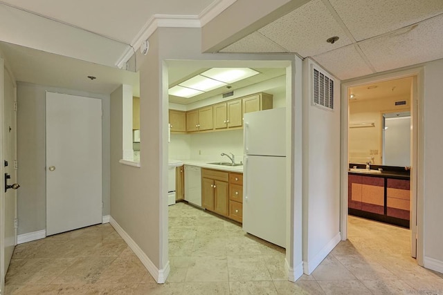 kitchen with a drop ceiling, sink, white appliances, and ornamental molding