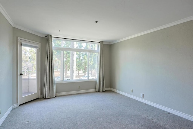 spare room with crown molding, a wealth of natural light, and light colored carpet