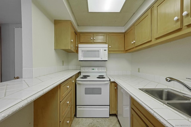 kitchen with sink, tile countertops, and white appliances