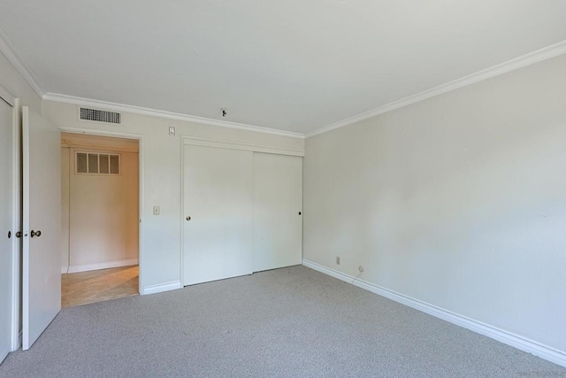 unfurnished bedroom featuring ornamental molding, carpet floors, and a closet