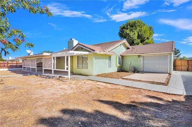 ranch-style home with a garage and a patio area