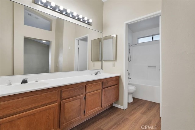 full bathroom featuring hardwood / wood-style flooring, vanity, shower / bath combination, and toilet