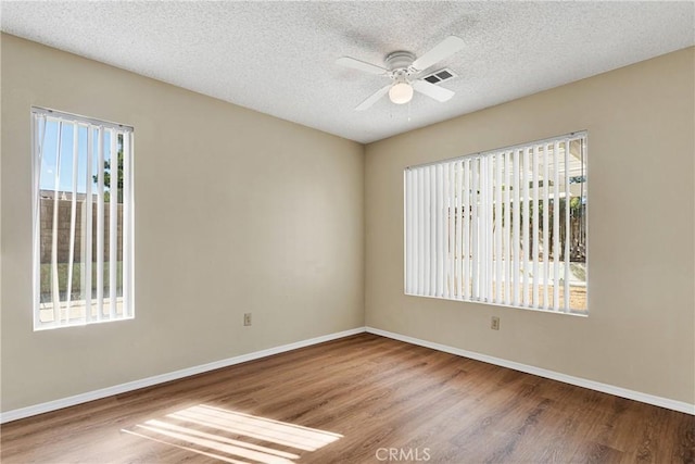 unfurnished room featuring ceiling fan, hardwood / wood-style floors, and a textured ceiling