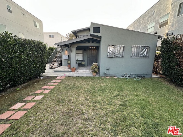 back of property with a patio and a lawn