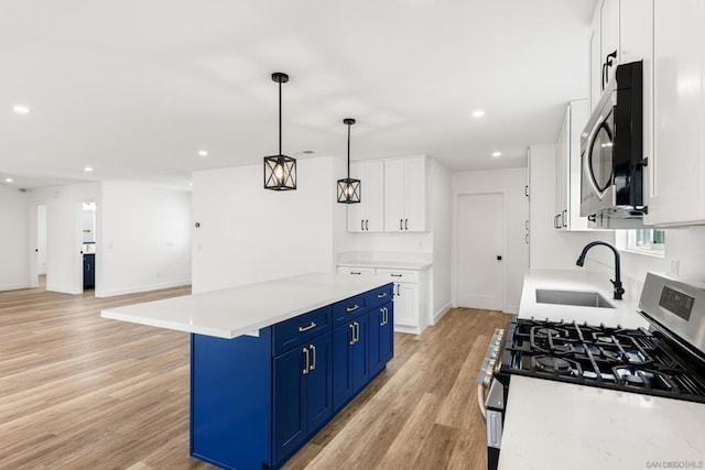 kitchen with stainless steel appliances, hanging light fixtures, blue cabinetry, and white cabinets