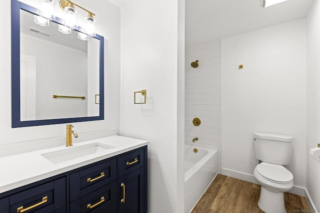 full bathroom featuring vanity, tiled shower / bath, wood-type flooring, and toilet