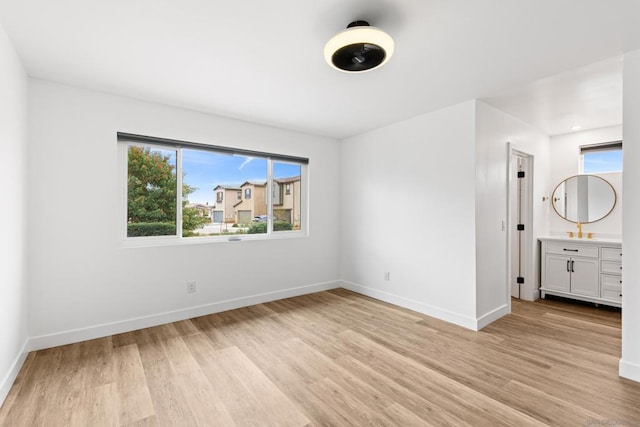 unfurnished bedroom with sink and light hardwood / wood-style flooring