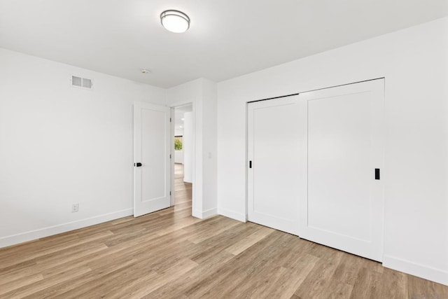 unfurnished bedroom featuring a closet and light wood-type flooring