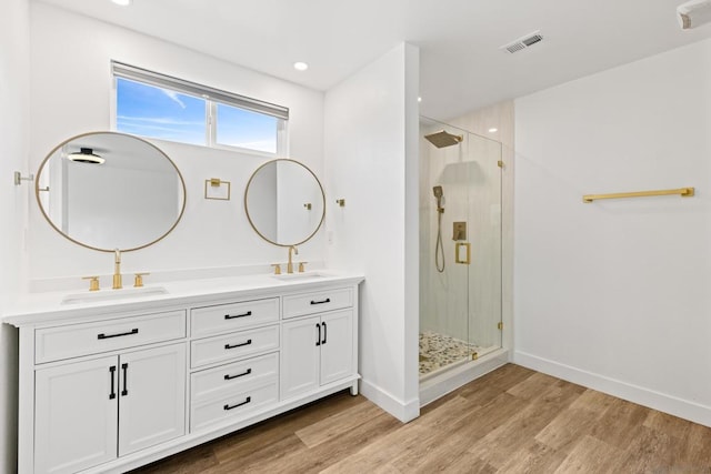 bathroom featuring vanity, hardwood / wood-style floors, and a shower with shower door