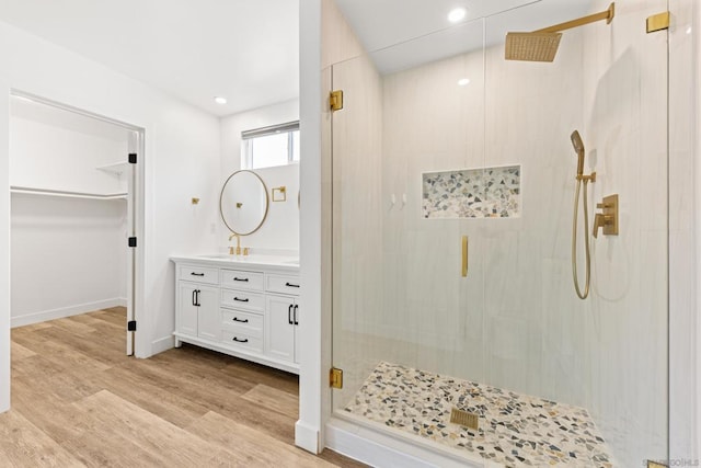 bathroom with hardwood / wood-style flooring, vanity, and walk in shower