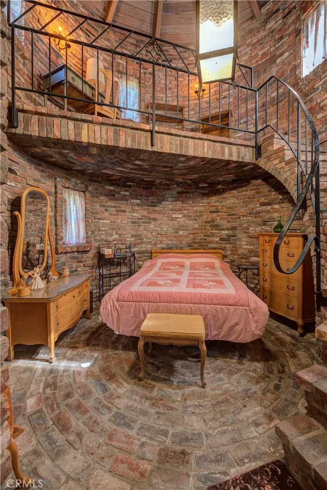 bedroom with pool table, brick wall, and a high ceiling