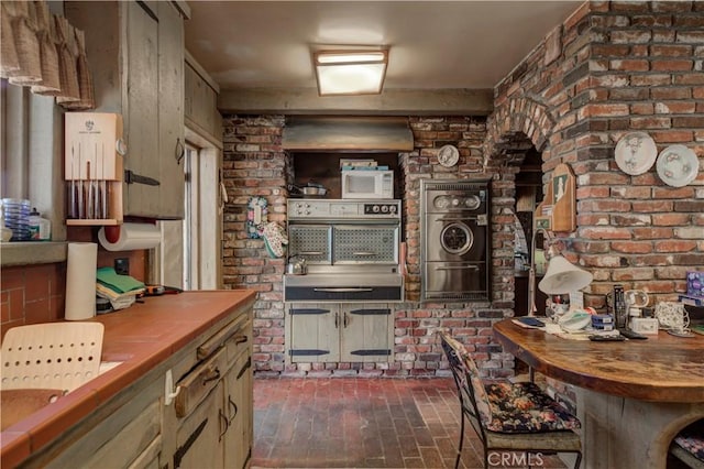 kitchen featuring brick wall and butcher block counters