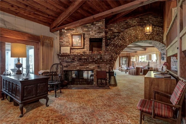 interior space with lofted ceiling with beams, carpet, wood ceiling, and a fireplace