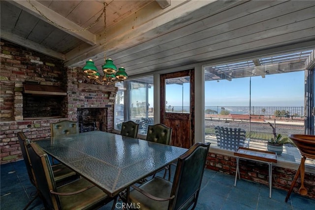 dining room with a healthy amount of sunlight, brick wall, and a fireplace