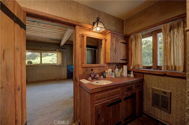 bathroom featuring vanity, beam ceiling, and heating unit