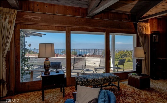 sunroom / solarium featuring wood ceiling, beamed ceiling, and a water view