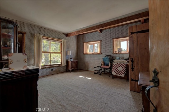 sitting room with beamed ceiling and carpet