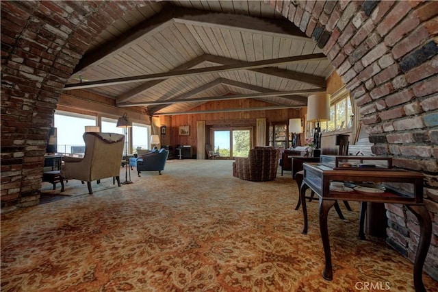 unfurnished living room featuring carpet, vaulted ceiling with beams, wood ceiling, and wooden walls