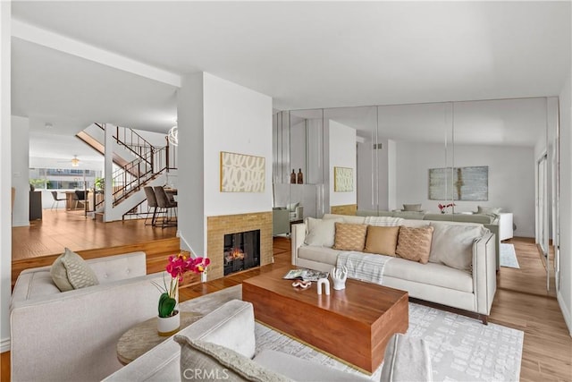 living room featuring a tile fireplace and light hardwood / wood-style flooring