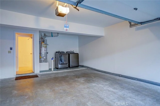 garage with a garage door opener, gas water heater, and independent washer and dryer