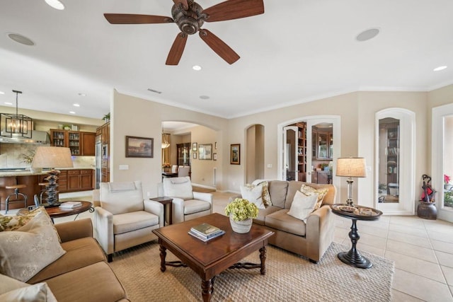 living room with light tile patterned flooring, ceiling fan, and ornamental molding