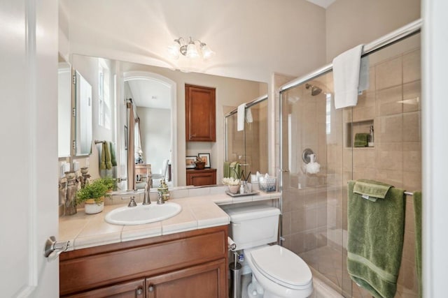 bathroom featuring walk in shower, vanity, and toilet