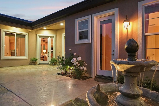 exterior entry at dusk featuring a patio