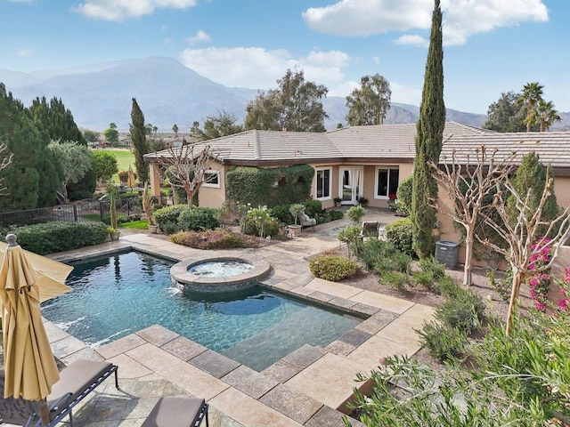 view of swimming pool featuring a mountain view, a patio, and an in ground hot tub